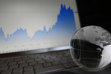 株価チャートとガラスの地球儀　世界経済のイメージ　Glass globe with graphs of stock prices	