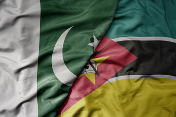 big waving realistic national colorful flag of pakistan and national flag of mozambique .