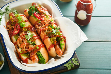 Delicious grilled hotdog with pickled  cucumbers, chili peppers, caramelized onions, ketchup,...