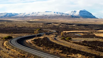 Foto op Canvas Patagonia Argentina. Famous road at town of El Calafate at Patagonia Argentina. Patagonia road landscape. Amazing landscape of desert scenery with nevada mountain. El Calafate at Patagonia Argentina. © ByDroneVideos