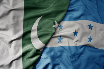 big waving realistic national colorful flag of pakistan and national flag of honduras .