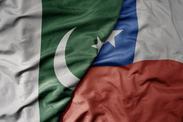 big waving realistic national colorful flag of pakistan and national flag of chile .
