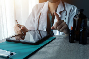 Research and experiments in the pharmaceutical or chemical industry. Female scientist in lab or chemist making notes on laptop by studying liquid in test tube. Scientists working on the background.