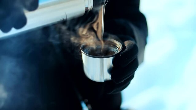 man heating his hands with hot cup of mate tea	