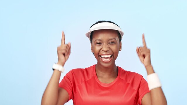 Tennis, pointing and excited black woman in celebration of winning in fitness isolated in a studio blue background. Victory, promotion and portrait of athlete with opportunity to workout in giveaway