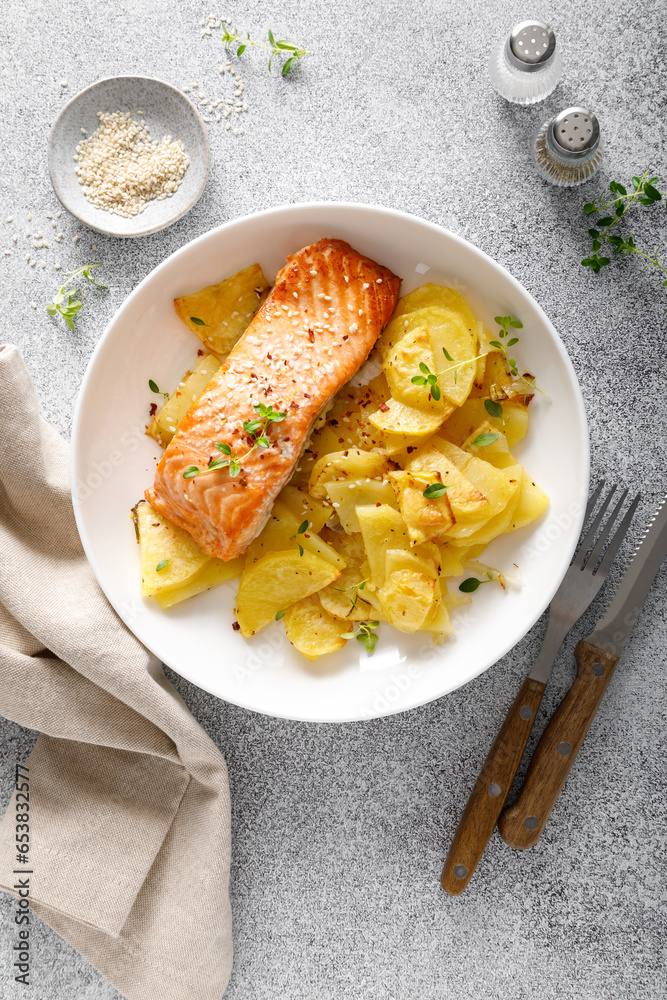 Wall mural salmon grilled and baked potato with onions, top down view