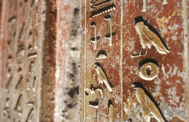 Close up of egyptian hieroglyphs on the red wall in The Museum in Cairo. Heritage of ancient civilization in archaeological excavation