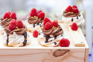 Mini cakes with whipped cream, chocolate, meringue and fresh raspberries. Confectionery poster for cafe or restaurant