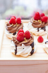 Mini cakes with whipped cream, chocolate, meringue and fresh raspberries. Confectionery poster for cafe or restaurant