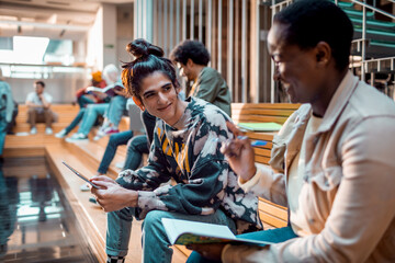Young and diverse group of student friends hanging out in a university lobby