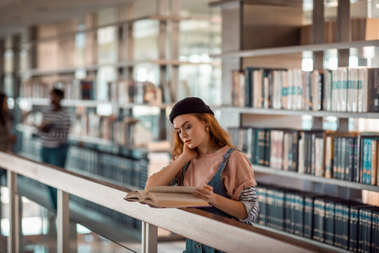 Young female student reading in the college library