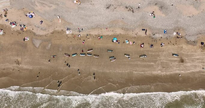 Top view of the beach with surfers walking with boards on the beach