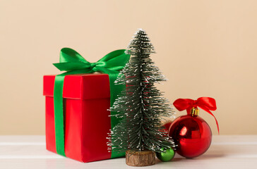 Red gift box with green ribbon and bow on table