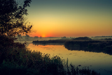 Fototapeta na wymiar Morning fog on the lake, sunrise shot. Summer or autumn landscape.
