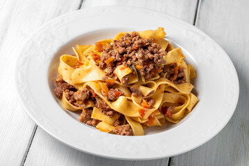 Obraz premium Tagliatelle, tipica pasta all'uovo italiana condita con ragu' di manzo, cibo europeo 