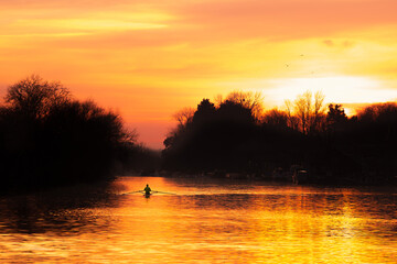 Single rower at  sunset on the river Thames at Hampton