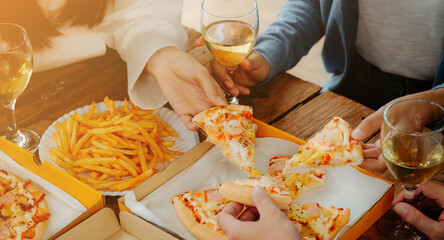 Group of young asian office girl friends having fun and celebrating pizza on table during party