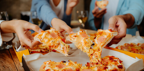 Group of young asian office girl friends having fun and celebrating pizza on table during party