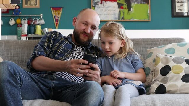 Dad shows his daughter on the phone photos and videos.