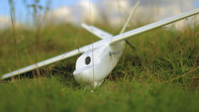 a radio-controlled plane made of extruded foam is lying on the grass
