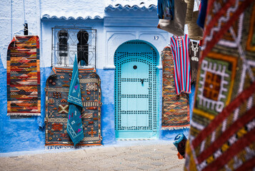 colorful blue wall and carpets on the streets of Chefchaouen Morocco