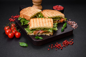 Delicious crispy sandwich with toast, salmon, avocado, tomatoes, salt, spices and herbs