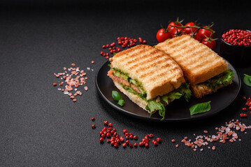 Delicious crispy sandwich with toast, salmon, avocado, tomatoes, salt, spices and herbs