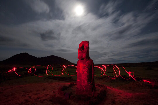 Moai at night beneath the light of the moon and surrounded by swirling hand held lights on Easter Island at Tongariki site, Chile; Easter Island, Isla de Pascua, Chile