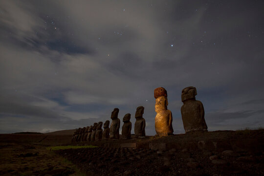 Moai stand as silhouettes beneath the night sky on Easter Island at Tongariki site, Chile; Easter Island, Isla de Pascua, Chile