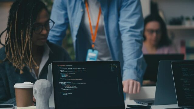 African American female software tester talking with a supervisor in office