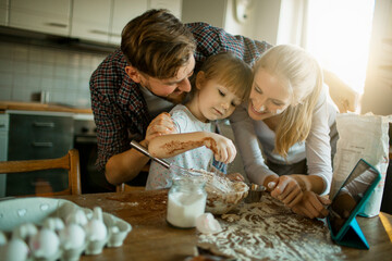 Young family baking and being messy in the kitchen at home
