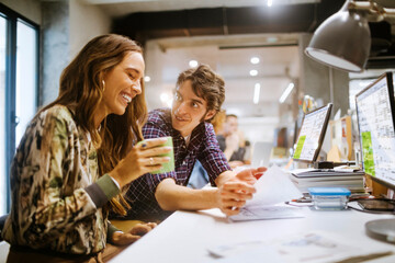 Young group of coworkers going over paperwork in the office of a startup company