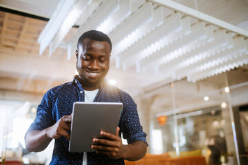Young African American man using a tablet in the office of a startup company