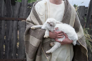 Foto op Canvas Shepherd with a sheep in his arms © Marina
