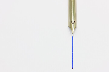 A gold pen with blue ink. Write line. Space for text.