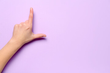 Woman showing loser gesture on lilac background