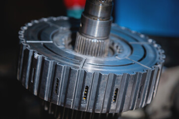 A close-up of a pack of clutches on a shaft with a gear from an automatic transfer case of a four-wheel drive car. Toned image.