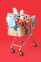 Shopping cart full of cleaning supplies on red background