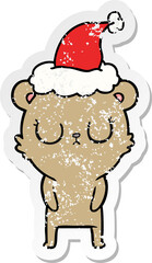 peaceful hand drawn distressed sticker cartoon of a bear wearing santa hat