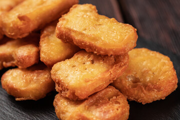 Fried chicken pieces on stone board with chopsticks - asian food close-up