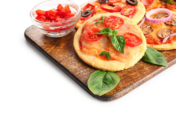 Board with different tasty mini pizzas and ingredients on white background