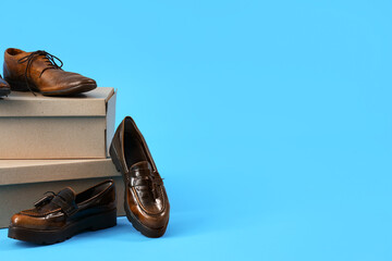Cardboard boxes with different male shoes on blue background