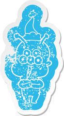 happy quirky cartoon distressed sticker of a alien wearing santa hat