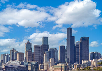 Fototapeta premium Seattle Washington downtown district cityscape with tall skyscrapers against a cloudy blue sky.