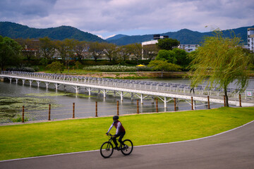 Suncheon City riverwalk and bike lane landscape with Poongdeok Swing Bridge crossing the Dongcheon River in Jeollanam-do, South Korea, on a beautiful and tranquil early summer morning