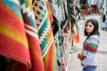 Fototapeta na wymiar Woman looking at traditional market stall in Otavalo, Ecuador