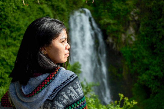 Portrait of South American woman with Peguche waterfall in the background, Ecuador