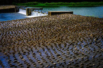 The Wildlife and Fishery Habitat Preservation river bank with rocks cemented along the slanted water flowing walls at the Dongcheon River in Suncheon City, Jeollanam-do, South Korea