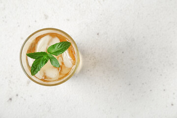 Glass of ice tea with mint on white background