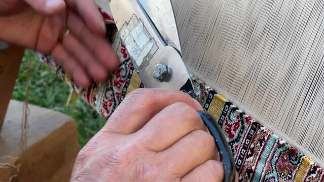 Hands of a woman weaving traditional handmade carpet , Woman hands on the weaving loom , Textile and carpet making